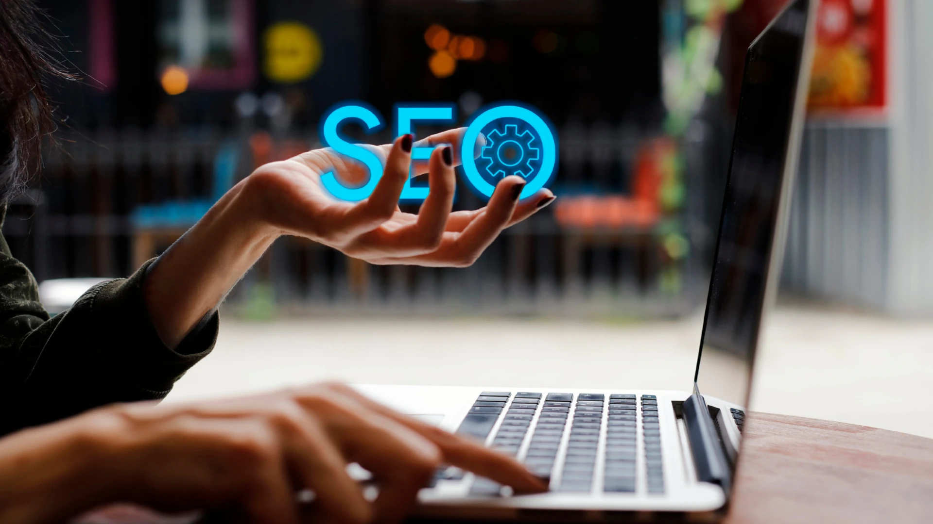 Business owner at a laptop with a glowing SEO hologram above their hand