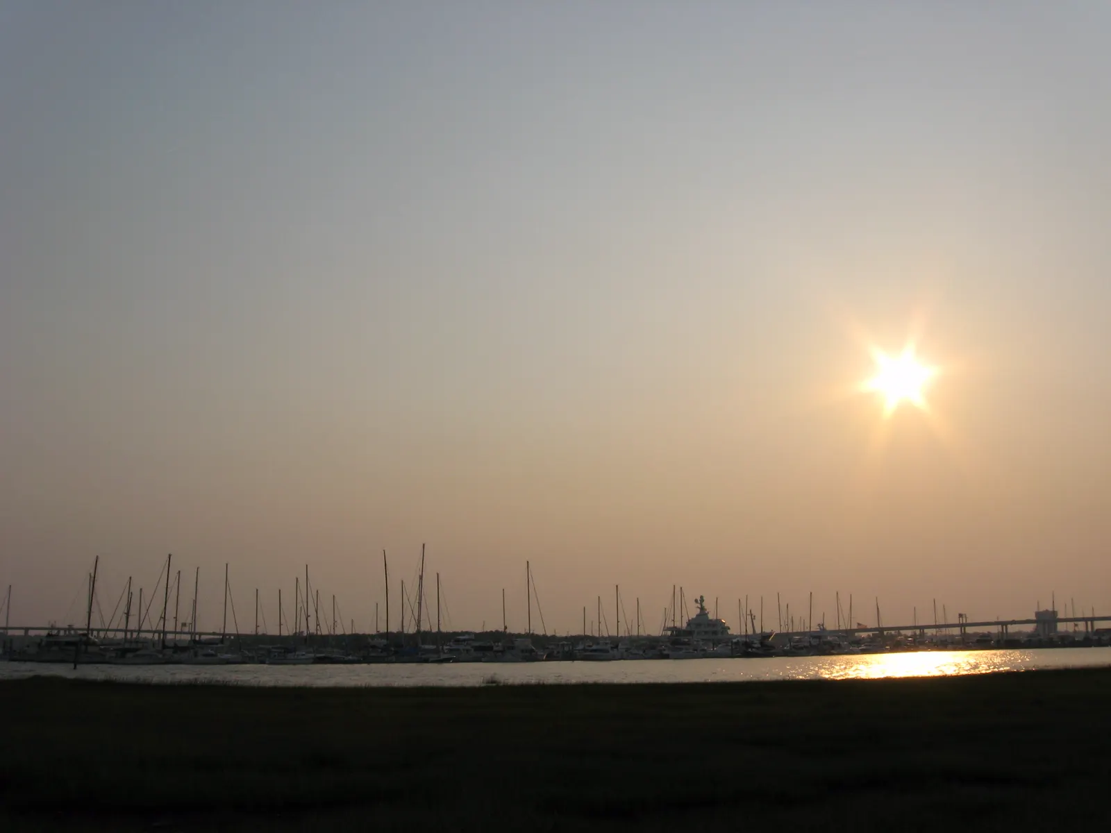 Charleston Harbor at golden hour with boats and the city waterfront